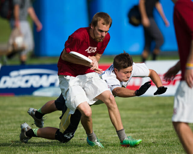 A Texas A&M player catches the disc under pressure at the 2014 College Championships.