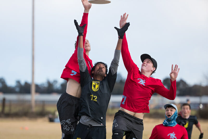 Two Wisconsin players attack a disc in the air against Colorado at the 2018 Stanford Invite.