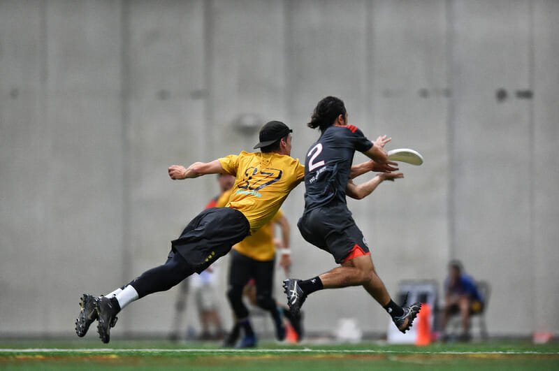 Revolver's Sawyer Thompson gets a layout block against Colony's Peter Eley in the WUCC 2018 final.