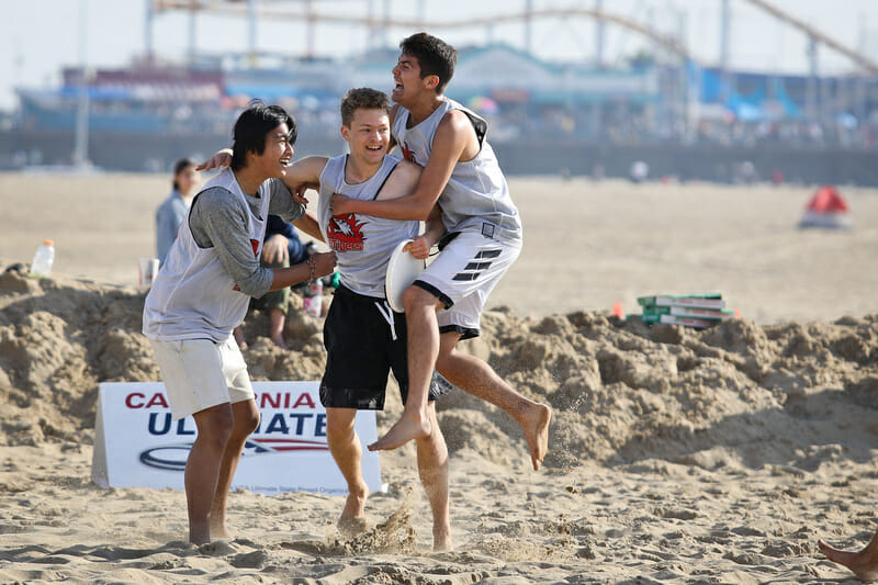 Players celebrate a win during u20 bracket play at the Beach of Dreams event. Photo: Kristina Geddert -- UltiPhotos.com