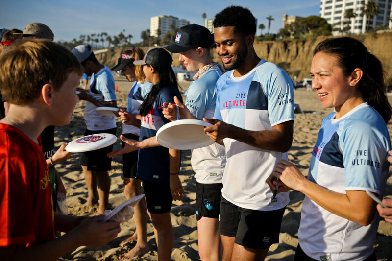 Live Ultimate ambassadors sign discs for youth players at the Beach of Dreams event. Photo: Kristina Geddert -- UltiPhotos.com