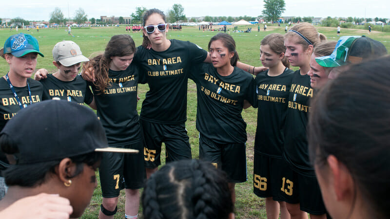 Jen Pashley (left, in green hat) leads a huddle for her team at the 2017 Youth Club Championships. Photo: Jolie J Lang -- UltiPhotos.com