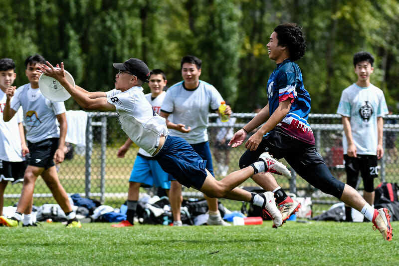 A player lays out in front of his teammates at the BCU Junior Club tournament. Photo: Jeff Bell -- UltiPhotos.com
