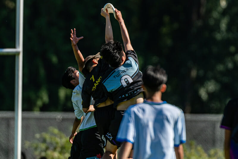 Players on the same team catch the disc at the same time at the BCU Junior Club tournament. Photo: Jeff Bell -- UltiPhotos.com