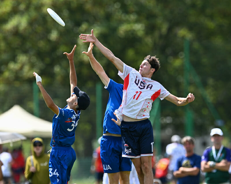 The United States' Will O'Brien rises above two Italian defenders in the teams' power pool matchup at WJUC 2022. Photo: Kevin Leclaire -- UltiPhotos.com