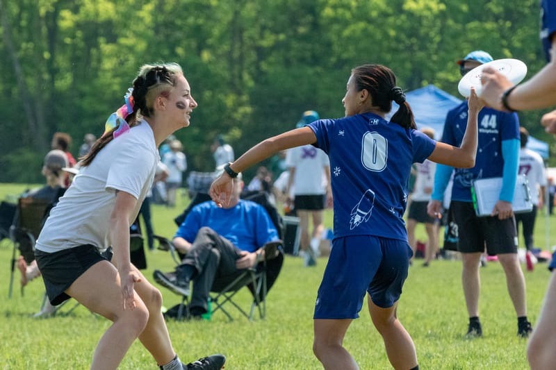 Wellesley's Tess Dolan (right, holding a frisbee) is marked by St. Olaf's Leina Goto in quarterfinals of the 2023 D-III College Ultimate Frisbee Championships. Photo: Kevin Wayner - UltiPhotos.com