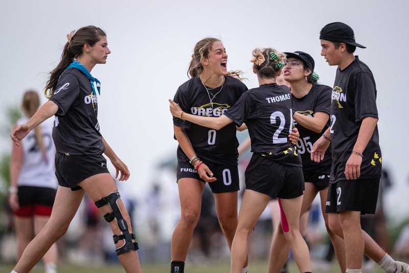 Oregon Fugue's Georgia Van der Linden surrounded by teammates during prequarters of the 2023 Ultimate Frisbee D-I College Championships. Photo: Sam Hotaling - UltiPhotos.com