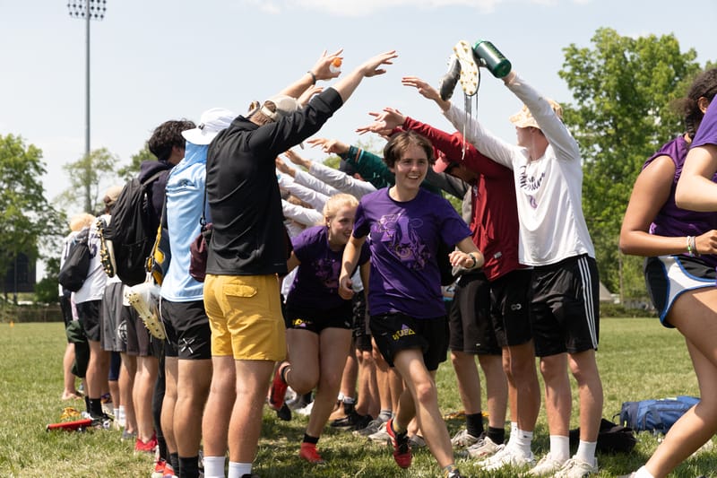 The Williams men's division team forms a tunnel for the Williams women's division team at the 2023 D-III Ultimate Frisbee College Championships. Photo: Kevin Wayner - UltiPhotos.com