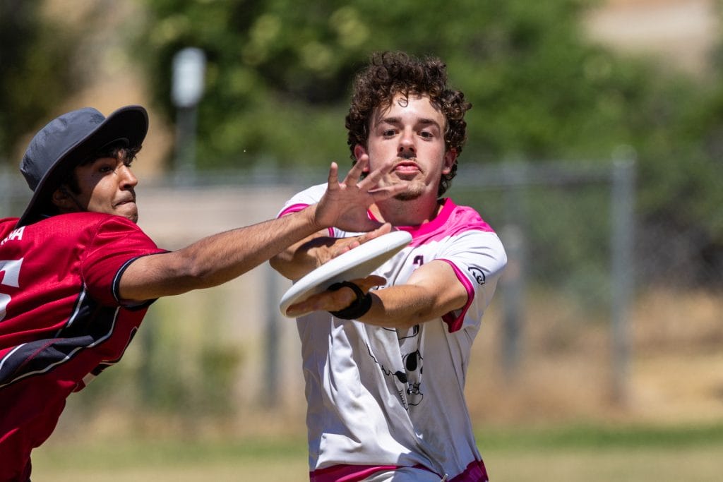 Claremont make the clap catch just past the outstretched arm of Santa Clara at 2026 Southwest Conferences. Photo: Marybeth Vellequette - UltiPhotos.com